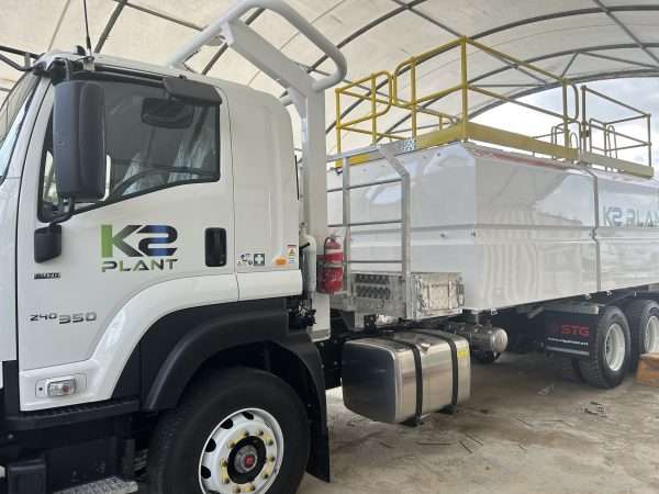 White service truck, in a workshop shop. K2 Plant logo is on the front passenger door.